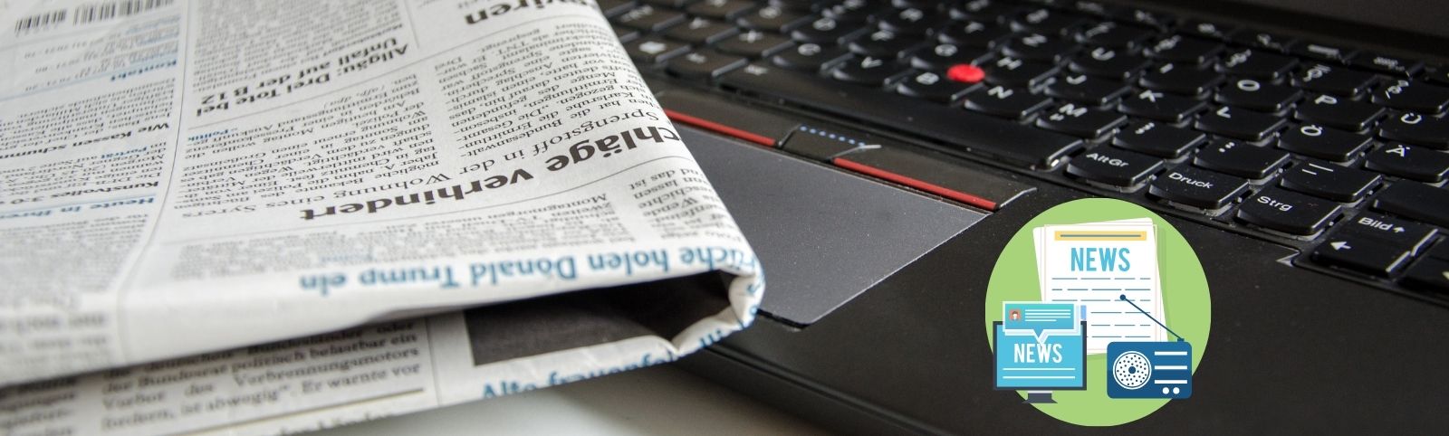 laptop with newspaper resting on it