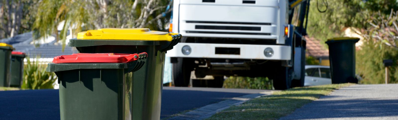 garbage bins with a garbage truck in the background